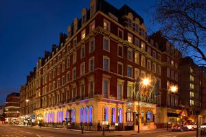 a large building with blue lights in front of it at The Bailey's Hotel London Kensington in London