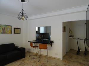 uma sala de estar com um sofá preto e uma mesa em La Rotonde em Cannes