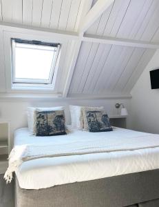 um quarto com uma cama grande e uma janela em Beach House For You - Luxe verblijf, 5 min van het strand em Katwijk aan Zee