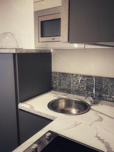 a kitchen with a sink and a microwave at Lumarooms B&B in Reggio Calabria