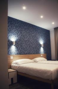 a bedroom with two beds and a blue wall at Lumarooms B&B in Reggio Calabria