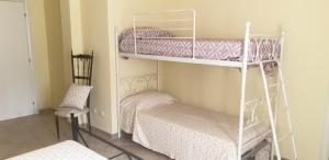 Sant' IsidoroにあるVilla Renzo e Luciaの二段ベッド2台と椅子が備わる客室です。