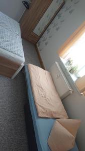 ein kleines Zimmer mit 2 Betten und einem Fenster in der Unterkunft Ferienwohnung Lehmann in Pirna