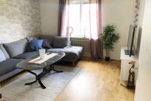 a living room with a couch and a table at Egen lägenhet i 2-familjshus på landet. in Tierp