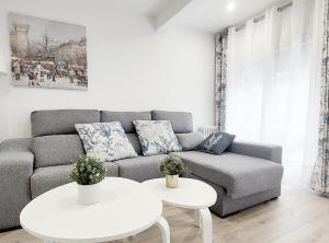 un soggiorno con divano e 2 tavoli di Apto Ramón y Cajal,1- Céntrico y cerca de Playa San Lorenzo-3hab garaje opc a Gijón