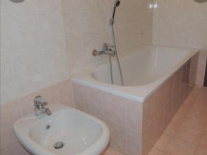La salle de bains est pourvue d'une douche, d'un lavabo et d'une baignoire. dans l'établissement Appartamento Jungle Beach, à Lido di Ostia