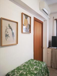 een kamer met een bed en twee foto's aan de muur bij Appartamento Jungle Beach in Lido di Ostia