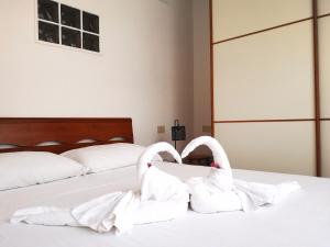 two white swans are sitting on a bed at Appartamento Jungle Beach in Lido di Ostia