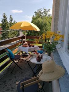 a patio with two tables and a yellow umbrella at Vendégház a Kerekhegyi Pagonyhoz in Zebegény