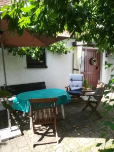 eine Terrasse mit einem Tisch, Stühlen und einem Sonnenschirm in der Unterkunft Oma‘s Häuschen in Schwenningen