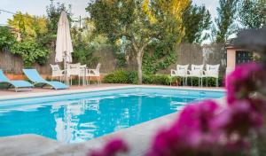 a swimming pool with chairs and an umbrella at Hostal Restaurante Rijujama in Matillas