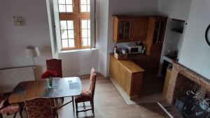 Salardine Apartments - Duplex with Modern Touch في Châlus: غرفة معيشة مع طاولة وكراسي ومطبخ