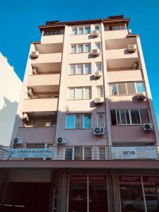 a tall tan building with windows and balconies at Studio Via Pontica in Varna City