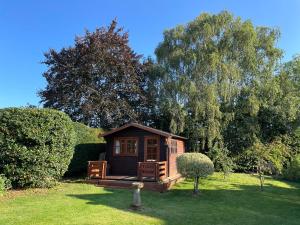a small cabin in the middle of a yard at 3 Bed Bungalow in Winchcombe, Cotswolds,Gloucester in Winchcombe