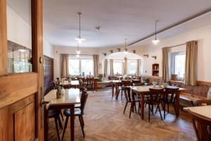 a restaurant with tables and chairs in a room at Bergwirt Hotel & Gasthof in Kiefersfelden
