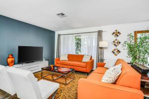a living room with orange furniture and a tv at Tangerine Dream Permit# 2444 in Palm Springs