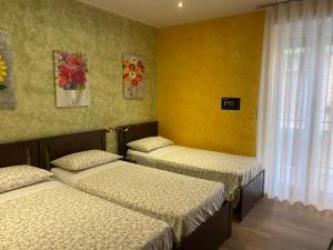 3 lits dans une chambre aux murs jaunes dans l'établissement B&B CATANIA CENTRO - Charme & More, à Catane