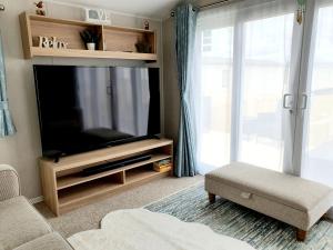 a living room with a flat screen tv and a couch at Premium accommodation with luxury HOT-TUB and decking area, near Fantasy Island in Ingoldmells