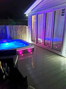 a swimming pool with purple lights in a house at Premium accommodation with luxury HOT-TUB and decking area, near Fantasy Island in Ingoldmells