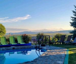 a pool with chairs and a view of the mountains at Wineyards Salin in Turda