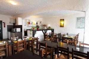 une salle à manger avec des tables et des chaises ainsi qu'une cuisine dans l'établissement Motel le Colibri, à Lucciana