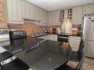 a kitchen with white cabinets and a black counter top at Primrose Cottage in Hayle