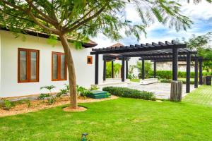 una casa con una pérgola en un patio en Ileverde 03 - Sun loungers Bungalow, en Punta Cana