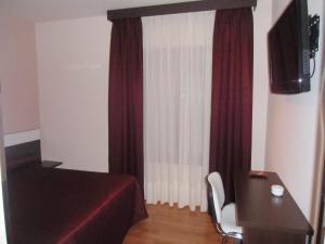 a room with a bed and a desk and a window at Area de Servicio Villamartín in Villamartín de la Abadía