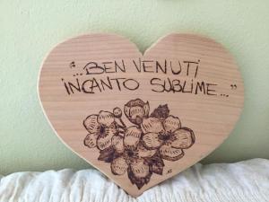 a wooden heart with a sign that reads a van ventiniini extrasie at Incanto Sublime in Verbania