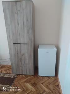 Pokój z drewnianymi drzwiami i białym pudełkiem w obiekcie Studio 1 w mieście Golubac