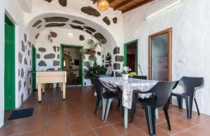 a dining room with a table and chairs and a piano at Casa Cueva El Caidero in Artenara