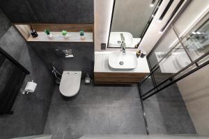 La salle de bains est pourvue d'un lavabo blanc et d'un miroir. dans l'établissement Dream apartament on Drahomanova street, à Lviv