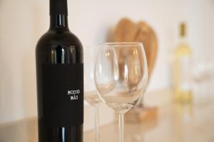 a bottle of wine and a glass on a table at Villa Cala Mesquida in Cala Mesquida