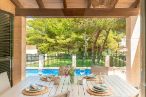a white table with plates on it on a patio at Villa Cala Mesquida in Cala Mesquida