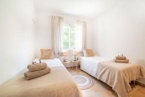 a bedroom with two beds and a window at Villa Cala Mesquida in Cala Mesquida +32 photos