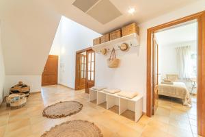 a living room with white walls and a large window at Villa Cala Mesquida in Cala Mesquida