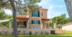a house with a balcony and trees at Villa Cala Mesquida in Cala Mesquida