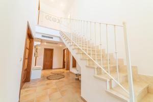 a staircase in a home with a white stair case at Villa Cala Mesquida in Cala Mesquida