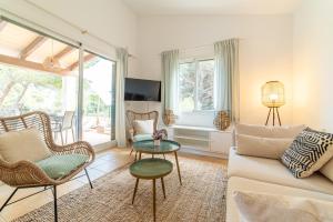 a living room with a couch and chairs and a table at Villa Cala Mesquida in Cala Mesquida