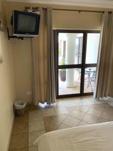 a bedroom with a bed and a tv on the wall at Almost Heaven in Durban