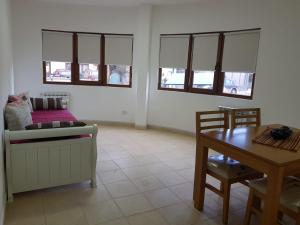 a living room with a couch and a table and windows at Alto Magallanes in Ushuaia