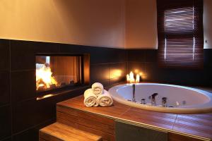 a bathroom with a bath tub with a fireplace at Theta Hotel Pelion in Agios Dimitrios