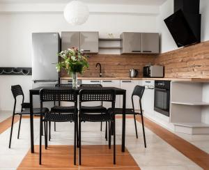 a black dining room table with black chairs in a kitchen at Apartmán v Žacléři Krkonoše in Žacléř