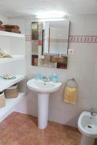 a white bathroom with a sink and a toilet at Estudio Cala Saona in Cala Saona