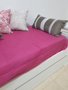 a bed with a pink comforter and pillows on it at Alto Magallanes in Ushuaia
