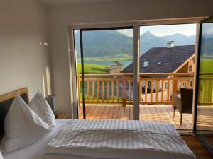 1 dormitorio con cama y vistas a un balcón en Ferienappartements Familie Jakob en St. Wolfgang
