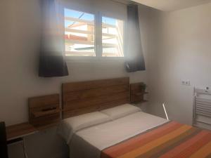 een slaapkamer met een bed en een raam bij La Estación in Sanlúcar de Barrameda