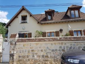 a white house with a stone wall at La Marlottine in Bourron-Marlotte +6 photos