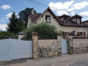 a house with a white fence and a white gate at La Marlottine in Bourron-Marlotte