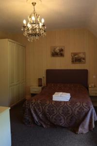 a bedroom with a bed and a chandelier at Haigs Hotel in Coventry